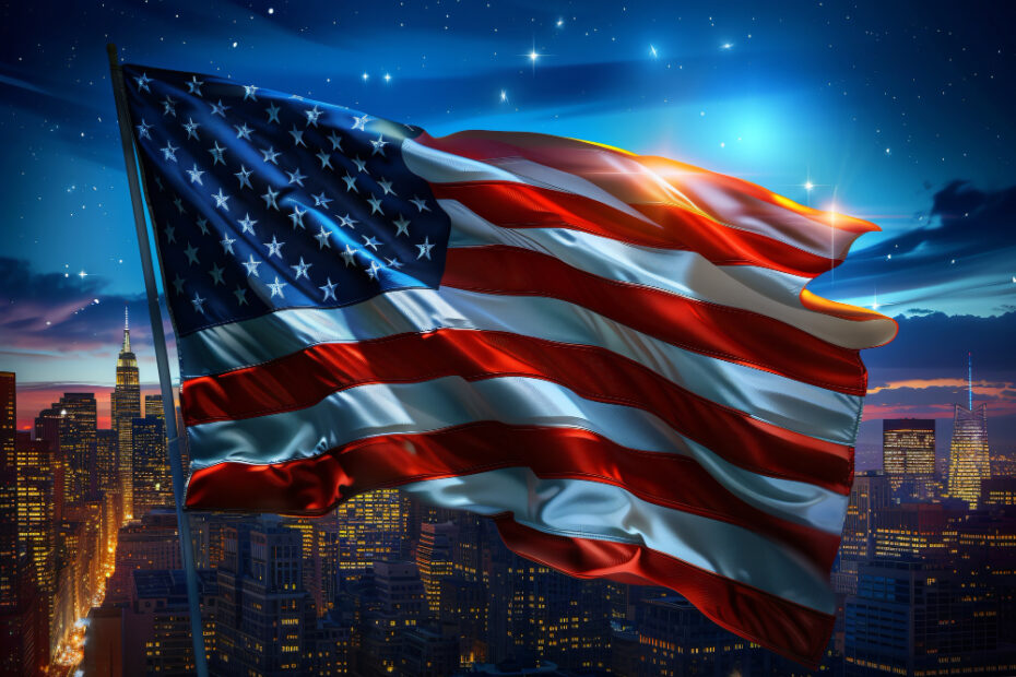 An American flag waves majestically against a backdrop of a cityscape at night. The city lights twinkle below, highlighting the tall skyscrapers, including a prominent one resembling the Empire State Building. The night sky is clear with stars shining brightly, adding a sense of serenity and pride to the scene. The flag stands out vividly, its red, white, and blue colors glowing against the deep blue of the night sky.