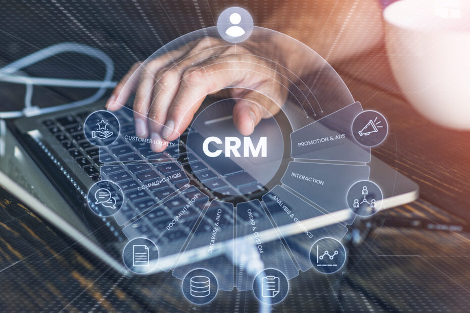 Person using a laptop with digital interface overlay showing custom CRM features such as customer loyalty, communication, documentation, data analysis, and integrations.